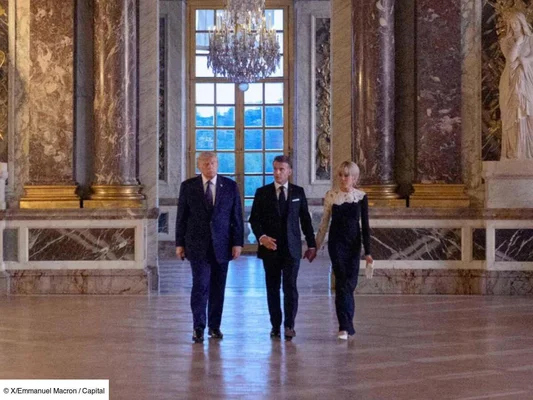 Donald Trump et Emmanuel Macron avançant dans une salle d'apparat du château de Versailles.