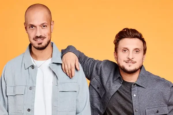 McFly et Carlito posant devant un fond jaune.