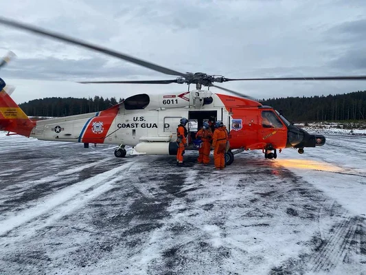 Hélicoptère HH-60 Jayhawk de la station aérienne de Kodiak sur tarmac enneigé.