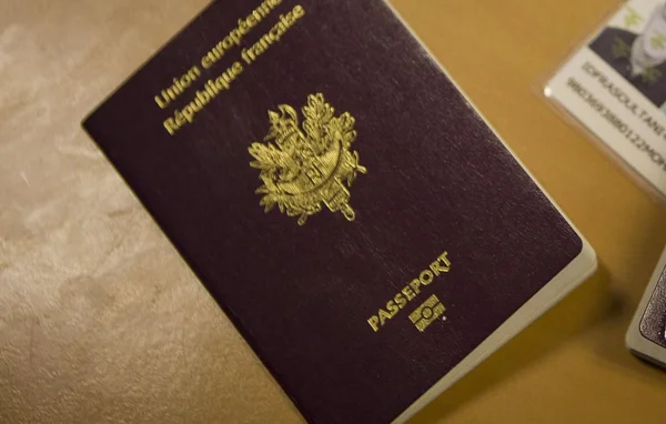 Passeport français et carte d'identité sur un fond beige.