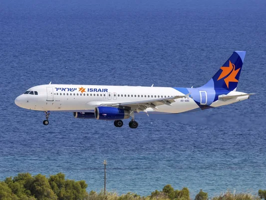 Un Airbus A320 d'Israir Airlines survolant l'océan, train d'atterrissage sorti, lors d'une escorte par l'armée de l'air israélienne.