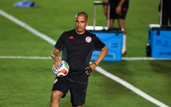 Sabri Lamouchi sur le terrain avec un ballon.