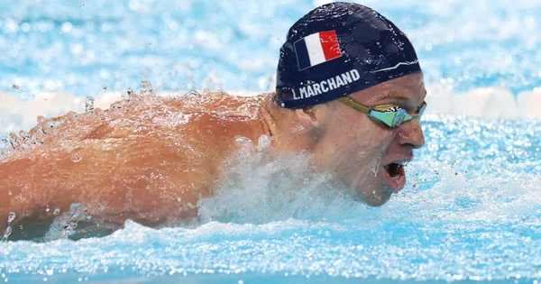Léon Marchand, nageur français, en pleine course sous les couleurs de l'équipe de France.