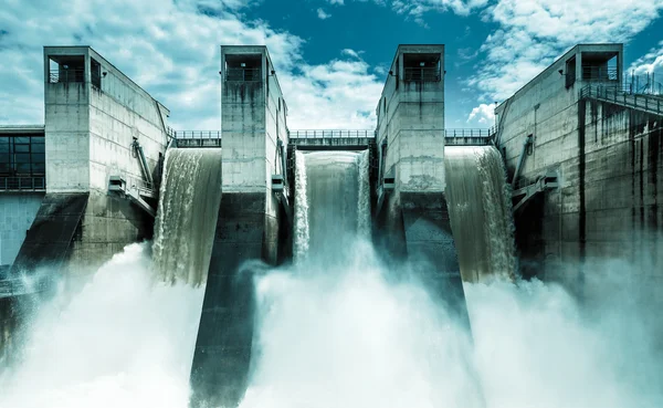 Barrage hydroélectrique en béton avec déversement d'eau, illustrant la production d'hydroélectricité en France.
