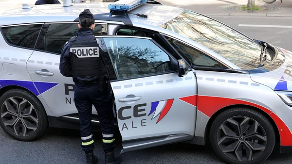 Un policier près d'un véhicule de police lors de l'enquête sur la fusillade mortelle à Valence.