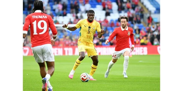 Thomas Partey dribblant face à des adversaires sous le maillot du Ghana.