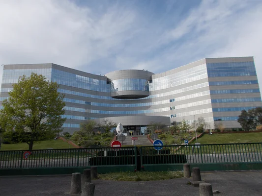 Siège d'Arabelle Solutions à Belfort, bâtiment moderne à façade vitrée et logo EDF, entouré d'espaces verts.