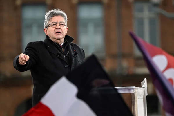Jean-Luc Mélenchon s'adressant à la foule lors d'un meeting de campagne en extérieur.