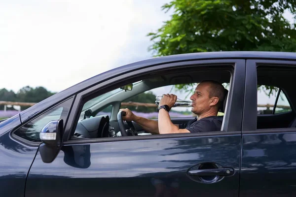 Conducteur se désaltérant au volant pendant une vague de chaleur.