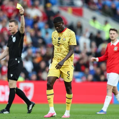 Un arbitre adresse un carton jaune à un joueur ghanéen lors d'un match