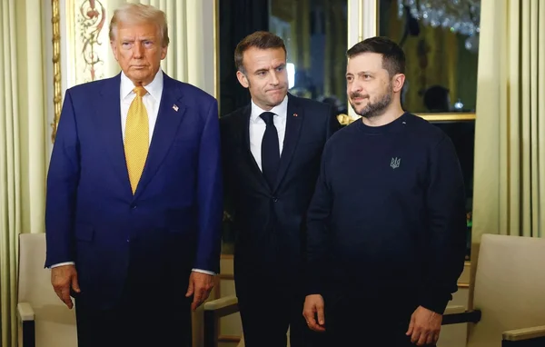 Poignée de main entre Volodymyr Zelensky et Donald Trump devant les drapeaux des deux nations.