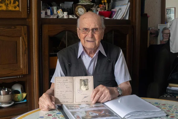 Albert Corrieri montrant son ancien livret d'identification.