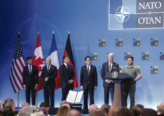 Joe Biden et Volodymyr Zelenskyy lors d'un sommet de l'OTAN, entourés de dirigeants alliés.