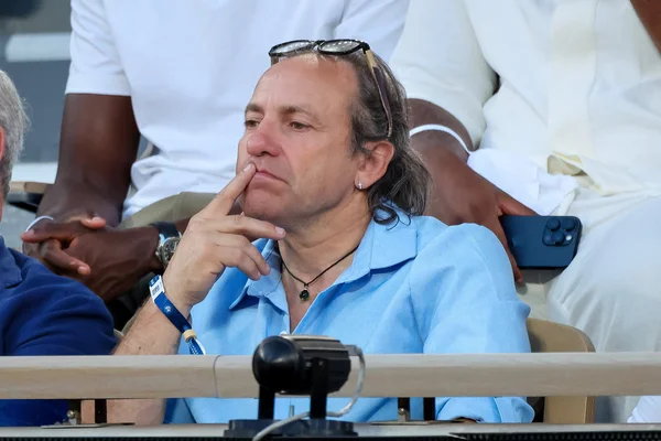 Philippe Candeloro, nouveau président de la Fédération française des sports de glace, assis dans un stade.