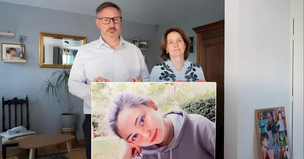 Les parents de l'étudiante Philippine tenant son portrait après l'adoption de la loi portant son nom.