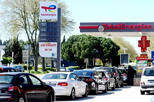 File de voitures à une station TotalEnergies, prix affiché à 2,09 €/L.