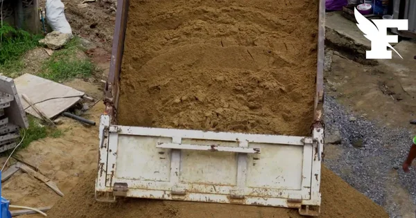 Camion-benne déversant du sable sur un chantier de terrassement en Gironde.