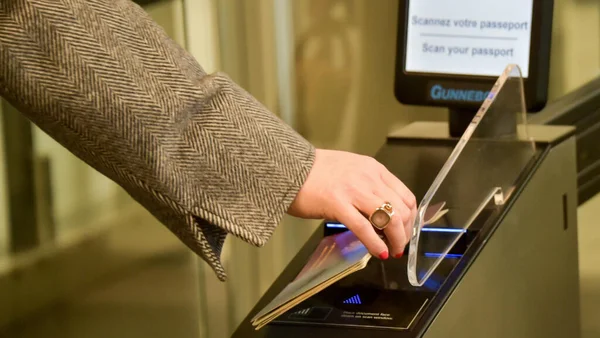 Voyageur insérant son passeport dans un portique automatisé du système EES dans un aéroport.