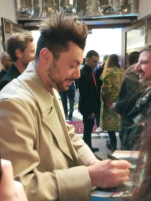 Kev Adams signant un autographe à l'avant-première de 'Maison de retraite 2'.