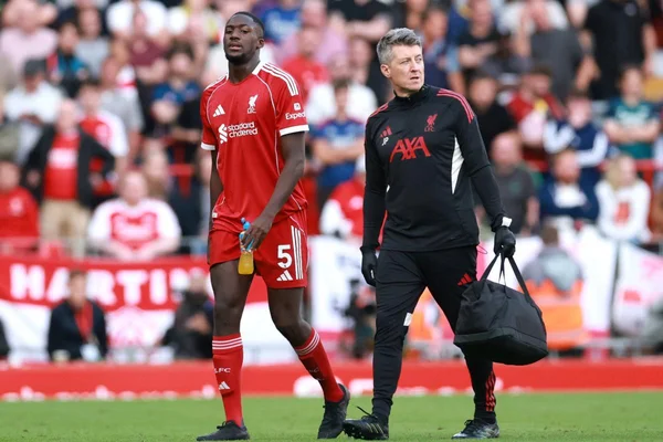 Ibrahima Konaté quittant la pelouse avec un soigneur lors de Liverpool-Arsenal.