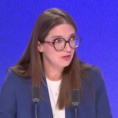 Aurore Bergé s'adressant à la presse depuis un pupitre.