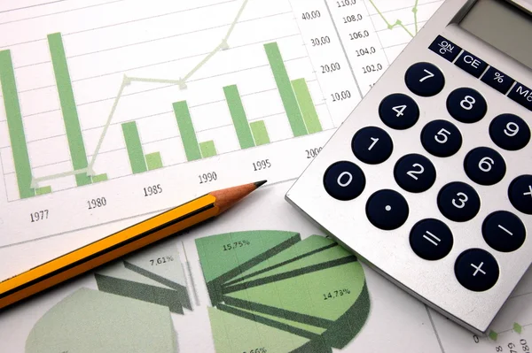 Calculatrice et crayon sur des documents financiers comprenant des graphiques et des diagrammes.