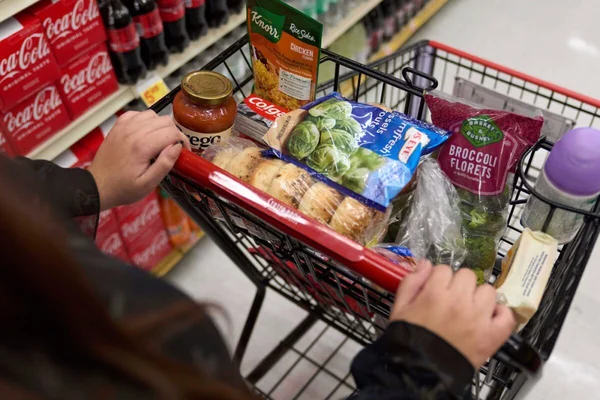 Un chariot de courses rempli d'aliments dans un supermarché, évoquant les achats des bénéficiaires du programme SNAP.
