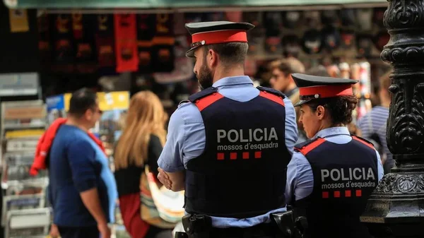 Agents des Mossos d'Esquadra en service dans un espace public.