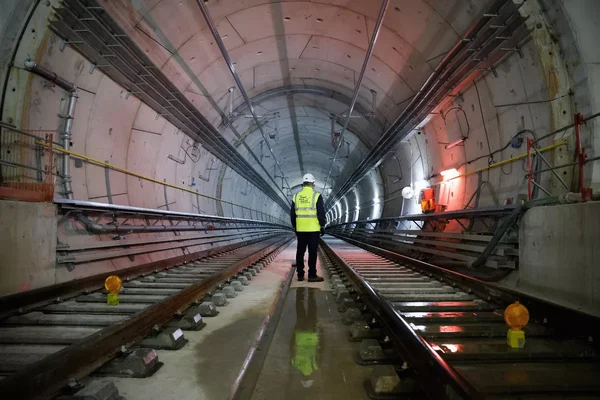 Ouvrier dans un tunnel du Grand Paris Express, illustrant les travaux en cours.