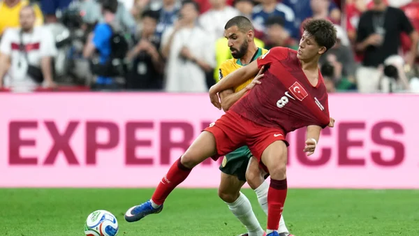 Action lors du match Australie-Turquie : un joueur turc en rouge tente de conserver le ballon face à un adversaire australien.