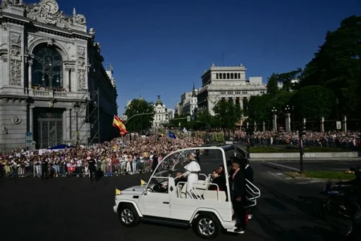 Le pape Léon XIV salue la foule depuis la papamobile dans les rues de Madrid.