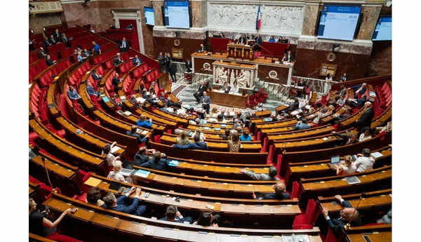 L'hémicycle de l'Assemblée nationale en session, avec les députés et les écrans de vote.