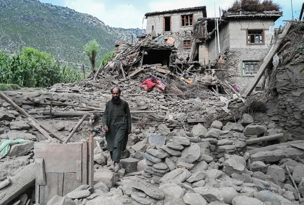 Un homme se fraye un chemin parmi les ruines d'un bâtiment effondré après le séisme.