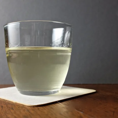 Un verre Duralex Gigogne contenant une boisson, posé sur une table en bois.