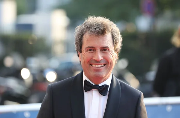 Omar da Fonseca en smoking noir, photographié en extérieur avec un arrière-plan lumineux.