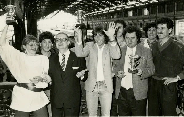 Le groupe Cookie Dingler pose avec trois trophées sous une arche, à l'occasion des 30 ans du tube « Femme libérée ».