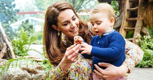 Kate Middleton et le prince Louis observant un objet lors d'une sortie en plein air.