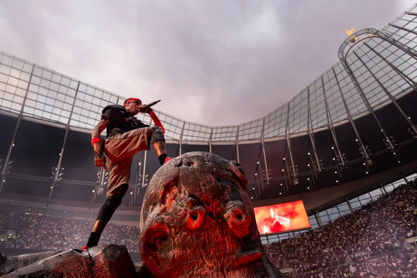 Travis Scott sur scène lors d'un concert à Londres, debout sur un accessoire en forme de crâne.