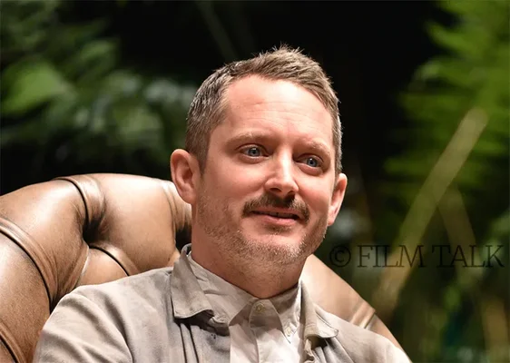 Elijah Wood dans un fauteuil en cuir.