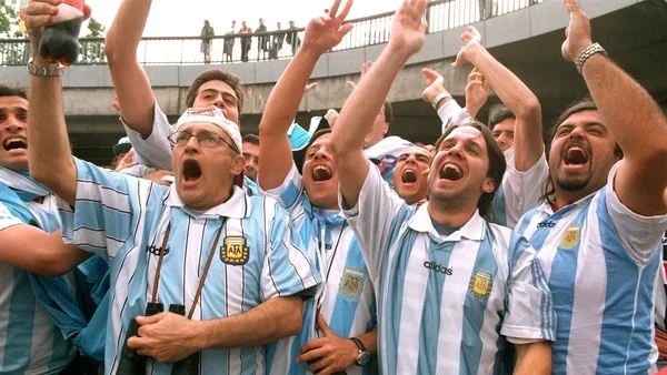 Supporters argentins en liesse dans un stade, arborant les couleurs de leur équipe nationale.