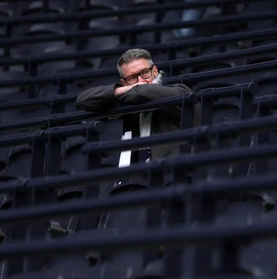 Un entraîneur ou membre du staff de Tottenham Hotspur observant depuis la tribune.