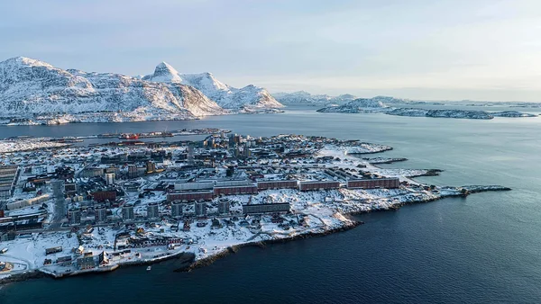 Vue aérienne d'une ville côtière groenlandaise sous la neige.