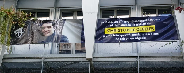 Banderoles de soutien à Christophe Gleizes, journaliste détenu en Algérie, accrochées à un balcon à Paris