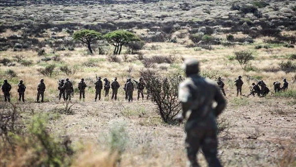Soldats en formation dans la savane, lors d'une cérémonie ou d'un déploiement militaire.