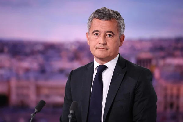 Bruno Retailleau lors d'une prise de parole devant la presse, avec une skyline urbaine en arrière-plan.
