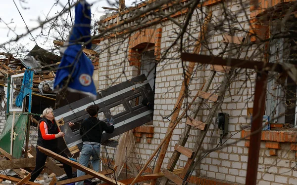 Des civils évacuent des débris après une frappe sur un marché à Nikopol.