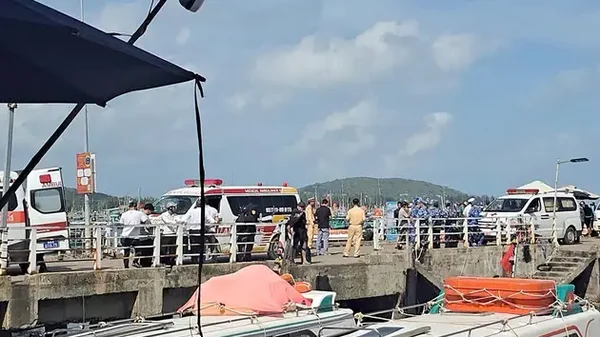 Secouristes et ambulances rassemblés sur un quai après le chavirement du bateau touristique.