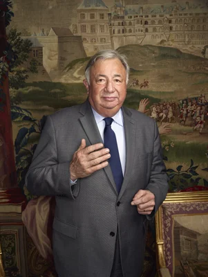 Gérard Larcher posant devant une tapisserie historique.