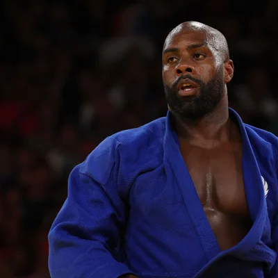Teddy Riner en kimono bleu, regard concentré.