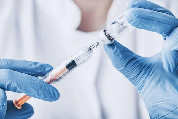 Préparation d'une injection de peptides par un professionnel de santé, soulignant les risques de l'auto-administration sans surveillance médicale.